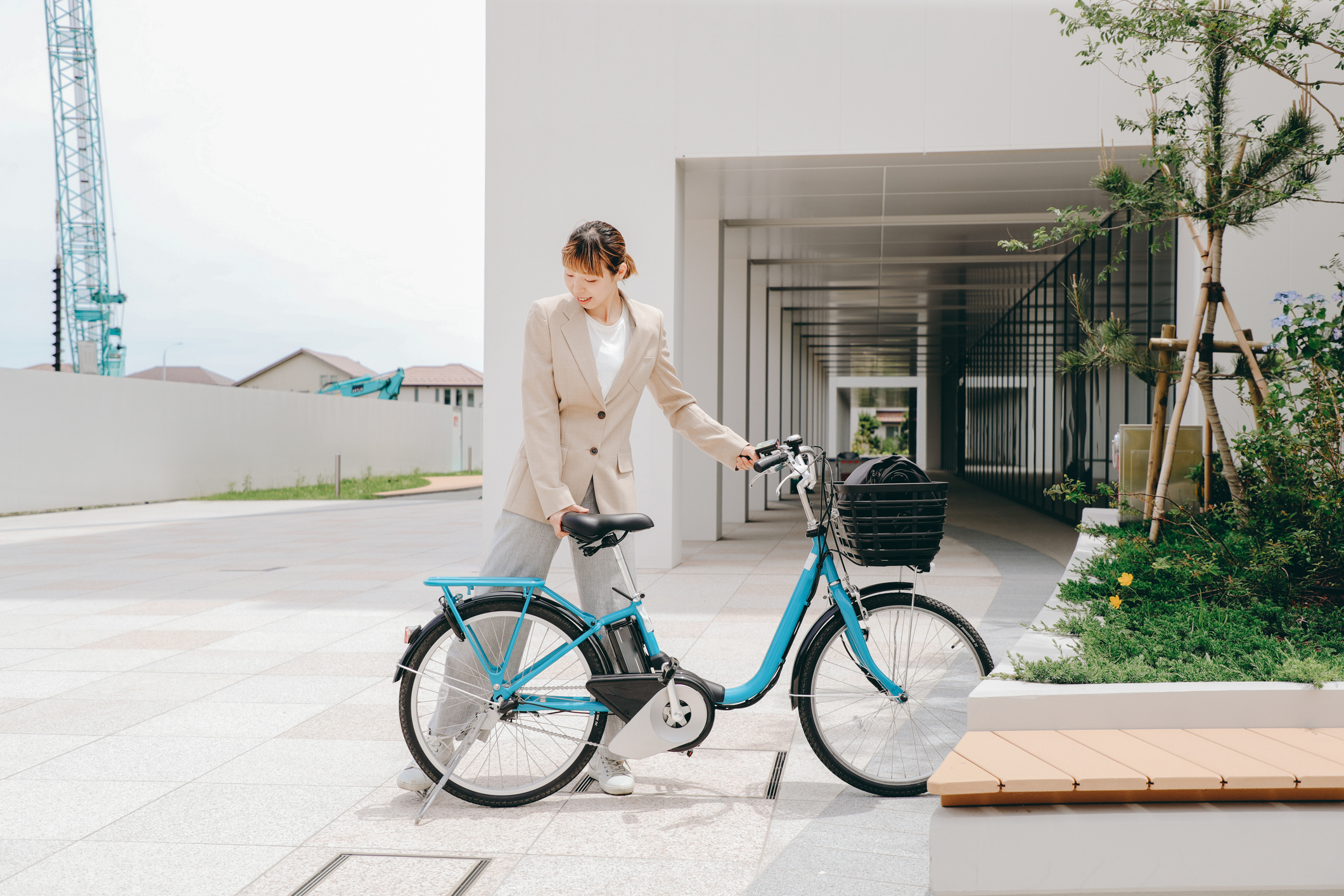 A busy Asian businesswoman parks a shared bicycle